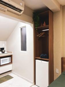 a kitchen with an open door into a kitchen with a stove at Rize Studios in Maceió