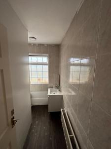 ein Bad mit einem Waschbecken und einem Fenster in der Unterkunft Joshmore in Attercliffe