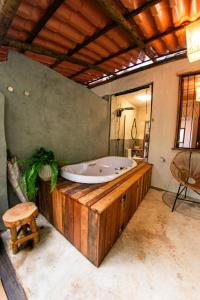 a bath tub in a room with a table and a stool at Recanto da Cachoeira in Brumadinho