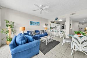 a living room with a blue couch and a table at Destin West Gulfside Two Bedroom with Bunks!!! Lazy River!! in Fort Walton Beach