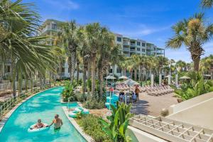 a pool at the resort with palm trees and people in it at Destin West Gulfside Two Bedroom with Bunks!!! Lazy River!! in Fort Walton Beach