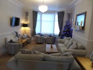 a living room with a christmas tree and a couch at Nathans Guest House in Blackpool