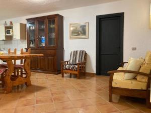 Il comprend un salon avec une table et des chaises ainsi qu'une cuisine. dans l'établissement AffittaSardegna-Casa Torpè, à Torpè