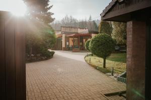 a brick walkway in front of a building with the sun shining at Apartamenty Pod Dzwonkiem in Wadowice