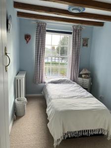 - une chambre avec un lit en face d'une fenêtre dans l'établissement Luxury Brick and Flint House in Funtington, à Chichester
