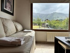 een kamer met een bed en een groot raam bij alojamiento en Bariloche CIPRES in Bariloche