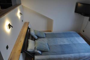 una camera con letto blu e televisore di Magnifique logement, 2 chambres, a Péruwelz