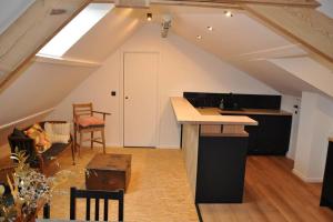 an attic room with a kitchen and a table at Magnifique logement, 2 chambres, in Péruwelz
