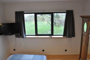 ein Schlafzimmer mit einem Fenster, einem Bett und einem TV in der Unterkunft Magnifique logement, 2 chambres, in Péruwelz