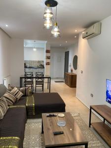 una sala de estar con un sofá y una mesa en Résidence palmerie, en La Marsa