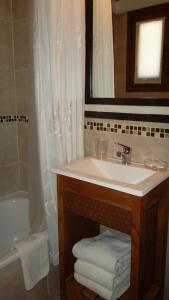 een badkamer met een wastafel, een spiegel en een bad bij alojamiento en Bariloche CIPRES in Bariloche