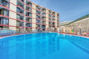a large swimming pool in front of a building at Suite Guinea 506 by Homestaygrancanaria in San Bartolomé de Tirajana