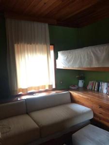 uma sala de estar com um sofá e uma janela em Casa in centro storico stile chalet di montagna em Ovindoli