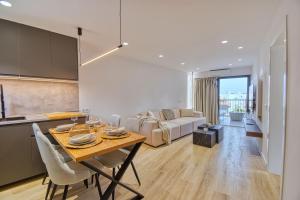 a kitchen and living room with a table and a couch at Suite Guinea 506 by Homestaygrancanaria in San Bartolomé de Tirajana