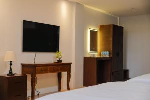 1 dormitorio con 1 cama y TV en la pared en Saffire Beach Resort and Glamping en Pagudpud