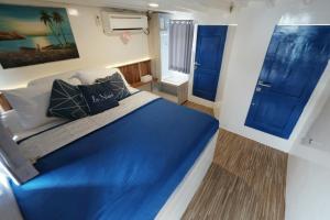um quarto com uma cama azul e duas portas azuis em Phinisi sailing Komodo 3 days 2 night em Labuan Bajo