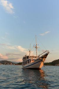 a boat sitting in the water on a lake at Phinisi sailing Komodo 3 days 2 night in Labuan Bajo