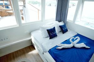 um quarto com uma cama com dois cisnes em Phinisi sailing Komodo 3 days 2 night em Labuan Bajo