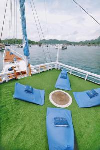 a boat with blue cushions on the deck at Phinisi sailing Komodo 3 days 2 night in Labuan Bajo