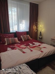 a bedroom with a bed with a christmas quilt on it at Apartament Dawna Mleczarnia Apartament Sosnowy in Nowa Ruda