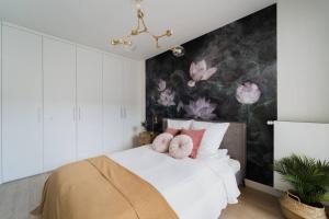 a bedroom with a bed with pink flowers on the wall at Luxury Apart - Młyn Maria in Wrocław
