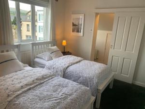 2 letti in una camera da letto con finestra di Oceanview House a Ballycastle