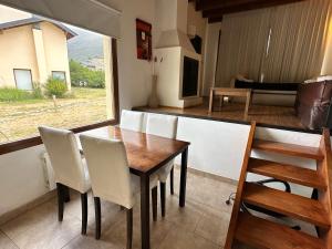 een eetkamer met een tafel en witte stoelen bij alojamiento en Bariloche CIPRES in Bariloche