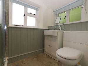 a bathroom with a toilet and a sink and a window at Alice's Cottage in Bridport +62 photos