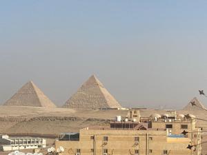 a view of the pyramids of giza and a city at Panorama 3 Pyramids View Inn in Giza