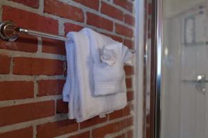 a towel rack with towels hanging on a brick wall at Premier Downtown Loft Building, Just Opened in Pensacola +31 photos