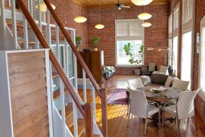 a room with a staircase and a table and chairs at Premier Downtown Loft Building, Just Opened in Pensacola