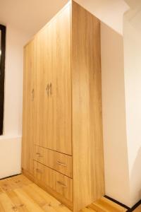 a large wooden cabinet in the corner of a room at Cozzy Loft-Blloku Downtown in Tirana