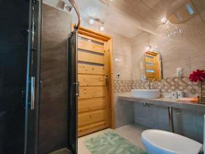 a bathroom with a shower and a toilet and a sink at Chata nad Roztokami in Mchawa