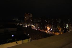 uma vista para uma cidade à noite com carros em Cozzy Loft-Blloku Downtown em Tirana