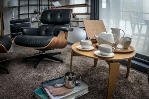 een woonkamer met een stoel en een salontafel met een stoel en een tafel bij Beautiful Loft 130m2 Sun and free parking in La Garenne-Colombes