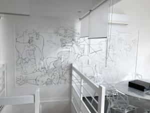 een tekening op een muur in een kamer met een tafel bij Beautiful Loft 130m2 Sun and free parking in La Garenne-Colombes +41 foto's