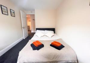 ブリストルにあるCharming Flat in Central Bristolのベッドルーム1室(ベッドにオレンジの枕2つ付)