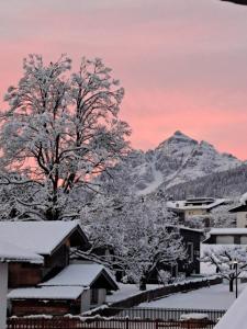 a snow covered town with a mountain in the background at Haus Muigg in Innsbruck +7 photos