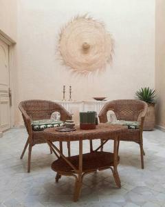 een woonkamer met een tafel en 2 stoelen bij Riad Nour, Maison de charme. in Marrakesh