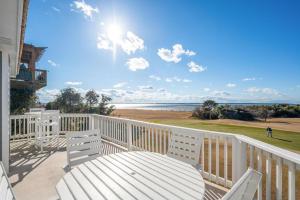 una terraza blanca con mesa y sillas en la playa en MS15 Sound View, en Nags Head