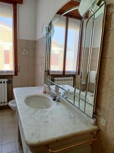 y baño con lavabo y espejo. en LILY - STORIE DEL BOSCO -, en San Felice sul Panaro