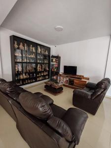 sala de estar con sofá de cuero y TV en Disfruta de paz y armonía en huaral, en Huaral