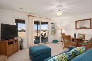 a living room with a blue couch and a tv at MS15 Sound View in Nags Head