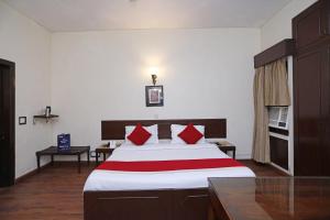 - une chambre avec un grand lit et des oreillers rouges dans l'établissement Hamilton Hotel, à New Delhi