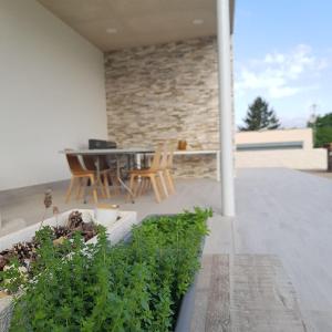 a patio with a table and chairs and plants at Casa Maria Dolors con piscina y jardin privado in Puig-Gros