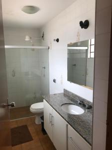 uma casa de banho com um lavatório, um WC e um espelho. em Pousada Florença em Amparo