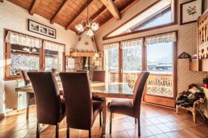 a dining room with a table and chairs and windows at Chalet Sun River - 8 pers in Morzine