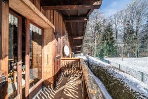 a porch of a wooden building with snow on the ground at Chalet Sun River - 8 pers in Morzine