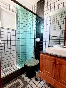 a bathroom with a toilet and a shower and a sink at Melhor Localização para WSL in Saquarema