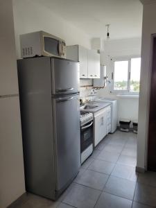 a kitchen with a refrigerator and a microwave on top of it at Amplio Monoambiente con buena ubicación in Paraná